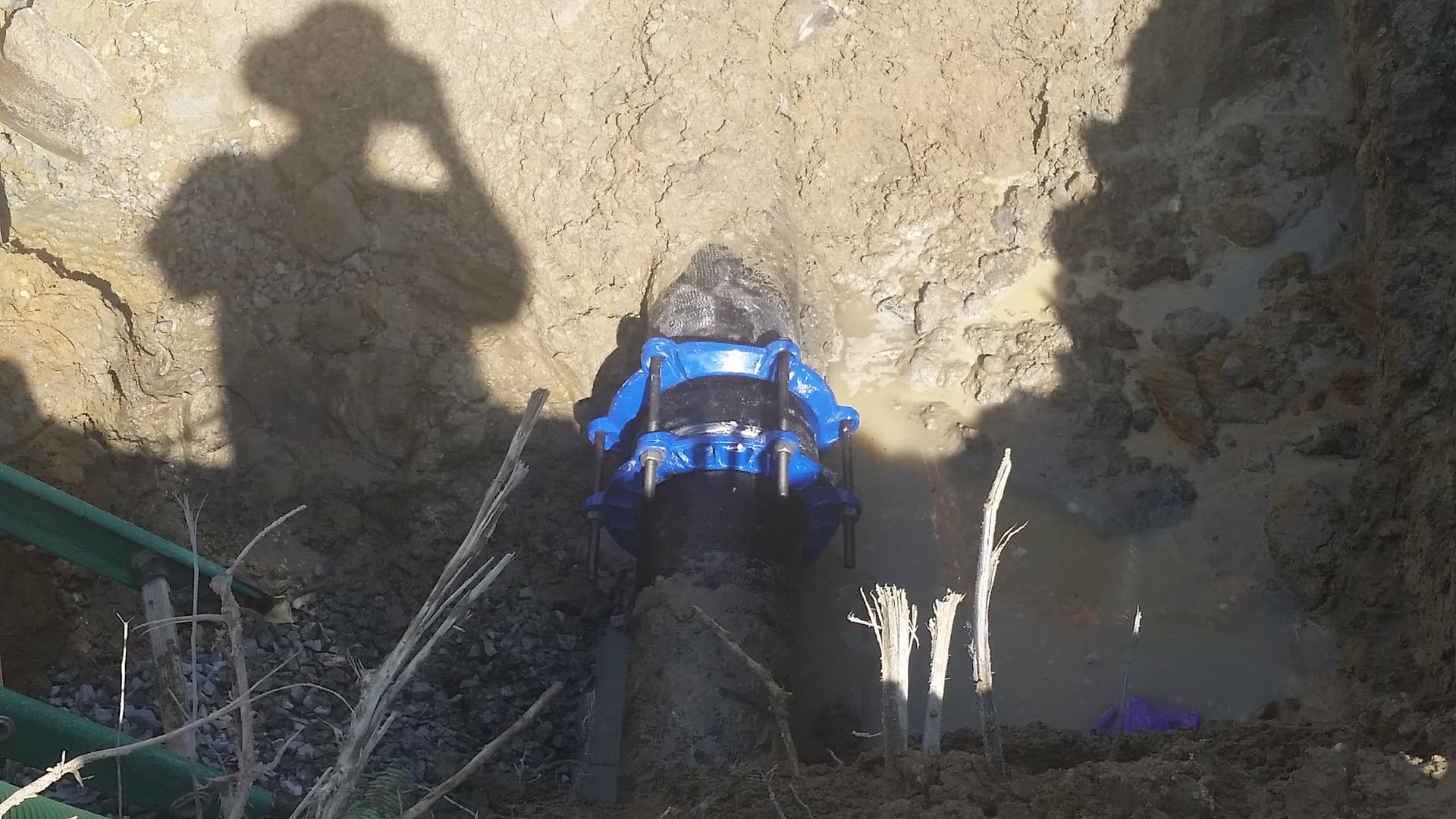 A repair clamp on a water main, six feet underground. Every fix like this costs tens of thousands of dollars and takes days.